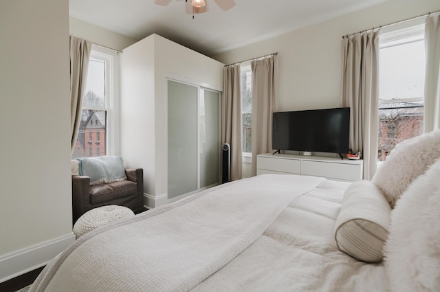 bedroom with a closet, baseboards, and ceiling fan