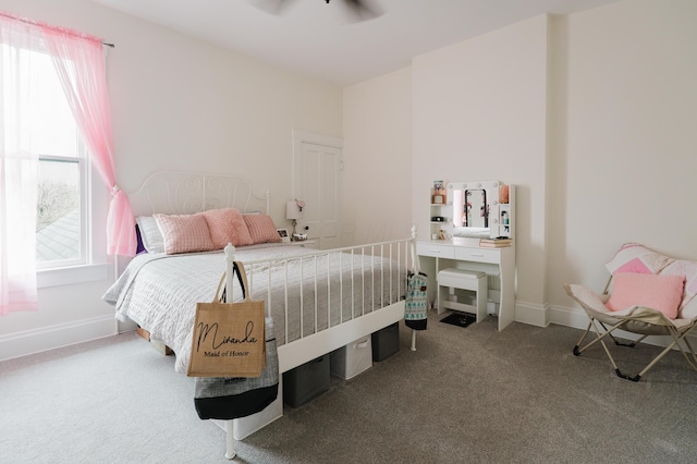 bedroom featuring baseboards, multiple windows, and carpet