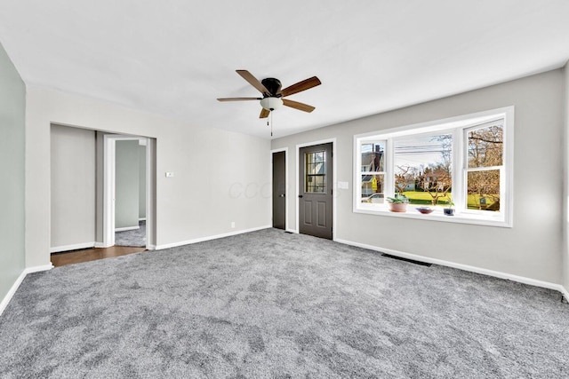 empty room with a ceiling fan, carpet floors, and baseboards
