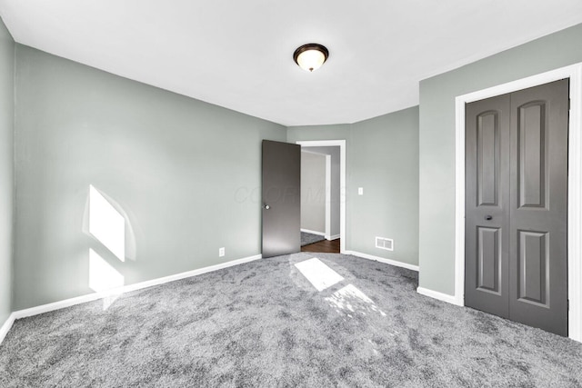 unfurnished bedroom with baseboards, visible vents, a closet, and carpet