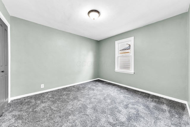 empty room featuring baseboards and carpet flooring