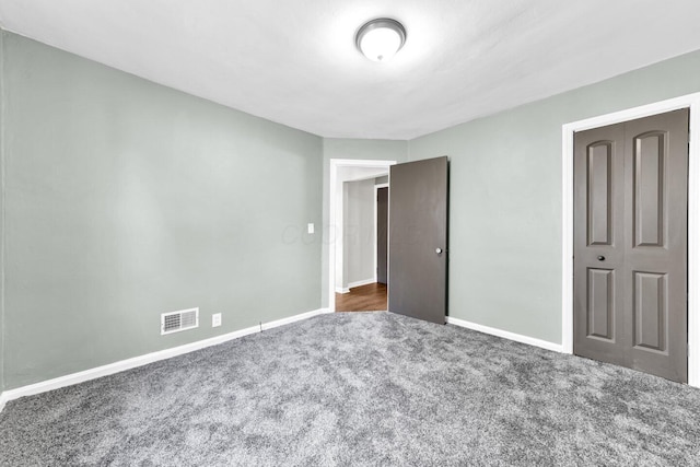 unfurnished bedroom with baseboards, visible vents, and carpet flooring