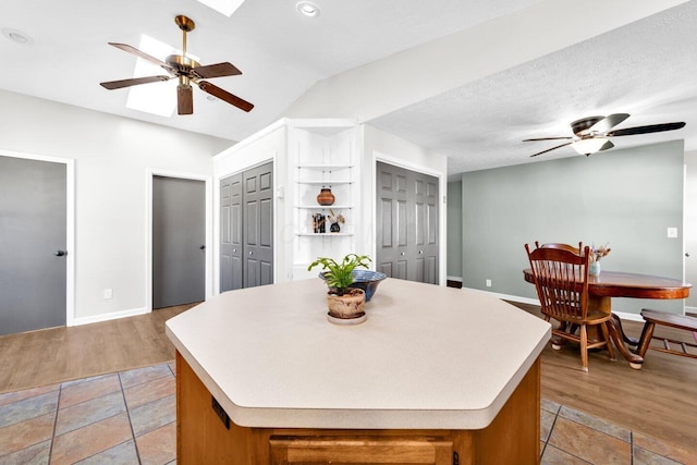 kitchen featuring light countertops, a center island, and a ceiling fan