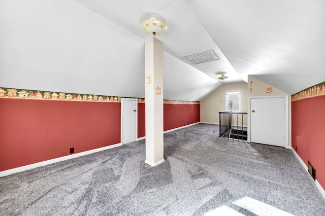 additional living space featuring baseboards, lofted ceiling, and carpet floors