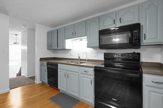 572 Sycamore Dr, Pickerington, OH 43147 - kitchen featuring black appliances, a sink, dark countertops, light wood-style floors, and ceiling fan