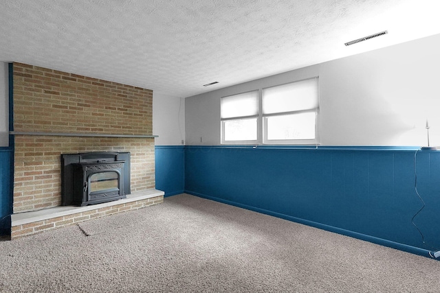 572 Sycamore Dr, Pickerington, OH 43147 - unfurnished living room featuring carpet floors, a textured ceiling, and a wainscoted wall
