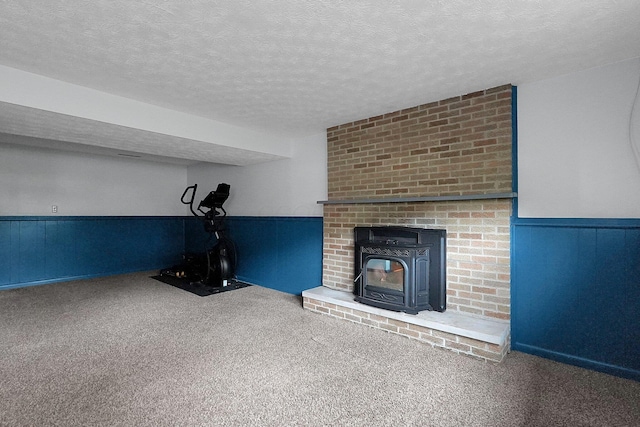 572 Sycamore Dr, Pickerington, OH 43147 - unfurnished living room with carpet, wainscoting, a wood stove, and a textured ceiling