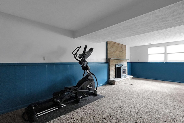 572 Sycamore Dr, Pickerington, OH 43147 - workout room featuring a wainscoted wall, carpet floors, a fireplace, and a textured ceiling