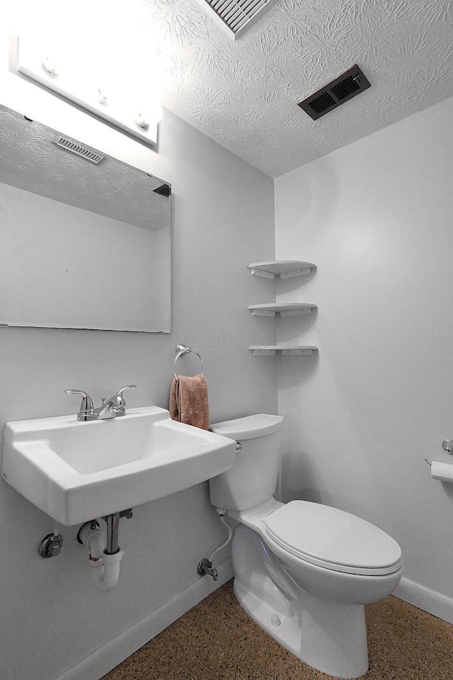 572 Sycamore Dr, Pickerington, OH 43147 - half bath with toilet, baseboards, a textured ceiling, and a sink