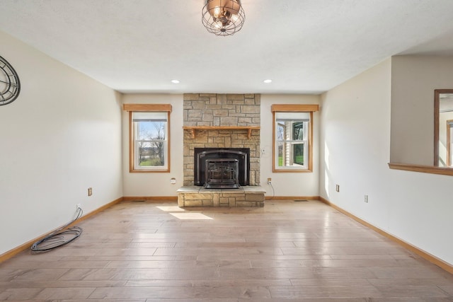 unfurnished living room with a healthy amount of sunlight, wood finished floors, and baseboards