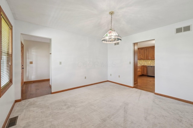 unfurnished room featuring visible vents, baseboards, and light colored carpet