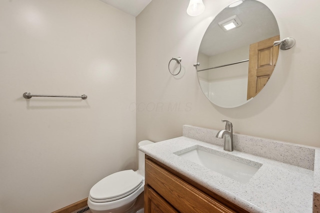 bathroom featuring vanity, baseboards, and toilet