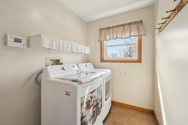 washroom featuring light wood finished floors, washing machine and dryer, laundry area, and baseboards