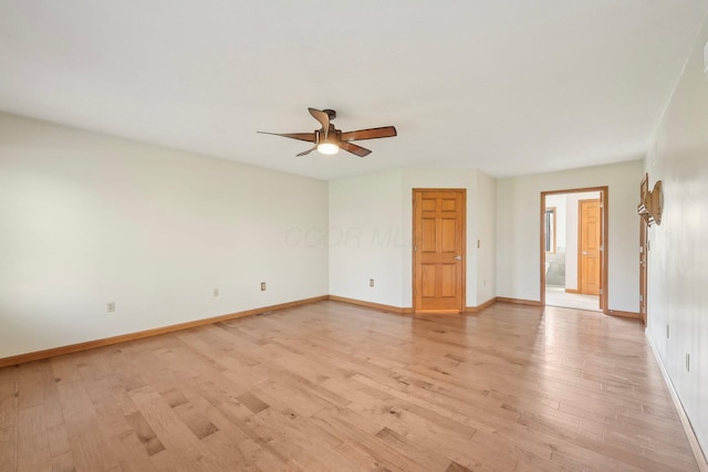 spare room featuring light wood-type flooring, baseboards, and a ceiling fan