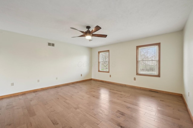 unfurnished room featuring light wood-style floors, visible vents, baseboards, and ceiling fan