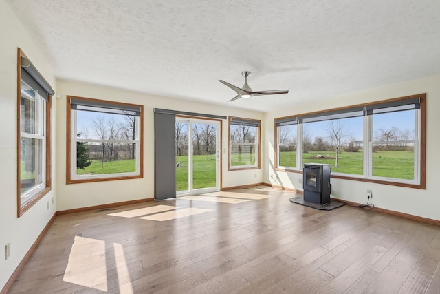 unfurnished sunroom featuring a wood stove