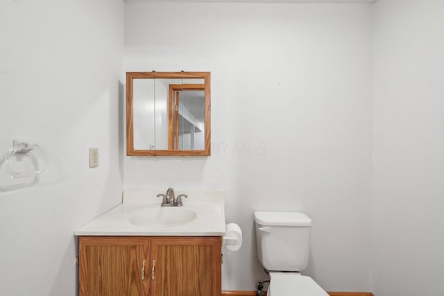 half bathroom featuring vanity and toilet