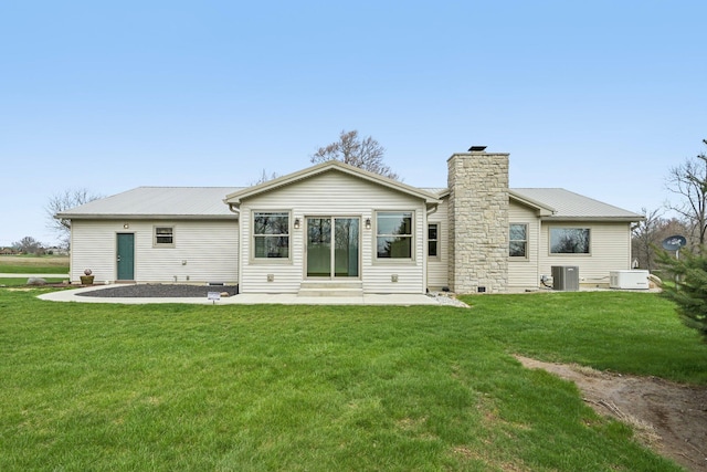rear view of property featuring a chimney, a patio, a lawn, and central air condition unit