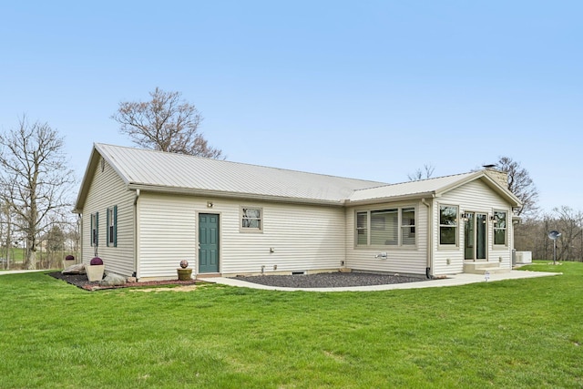 back of house featuring a yard, metal roof, and entry steps