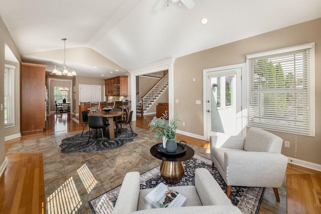 4568 Hickory Rock Dr, Powell, OH 43065 - living room featuring light wood-type flooring, vaulted ceiling, baseboards, ceiling fan with notable chandelier, and stairway