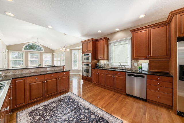 4568 Hickory Rock Dr, Powell, OH 43065 - kitchen featuring lofted ceiling, a sink, light wood-type flooring, appliances with stainless steel finishes, and a notable chandelier