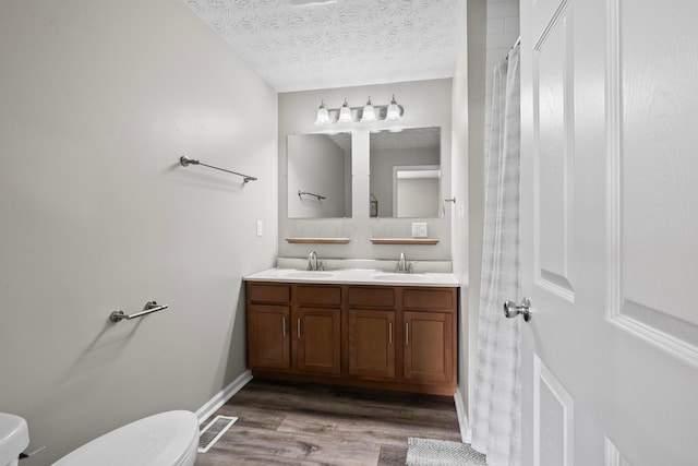 bathroom featuring a sink, visible vents, and toilet