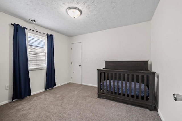 carpeted bedroom with visible vents, a textured ceiling, and baseboards