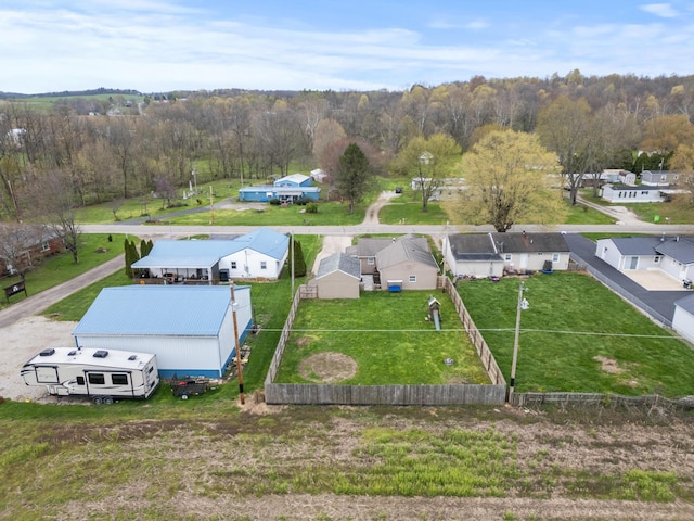 drone / aerial view featuring a wooded view and a residential view