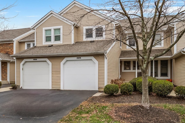 multi unit property featuring driveway, a garage, and roof with shingles