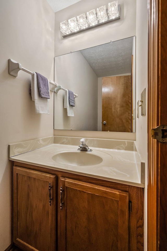 bathroom featuring a textured ceiling and vanity