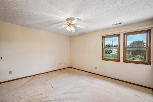 unfurnished room featuring a ceiling fan, light carpet, baseboards, and visible vents