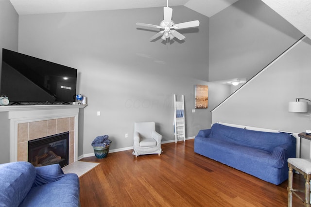 living area with baseboards, ceiling fan, a fireplace, stairway, and wood finished floors