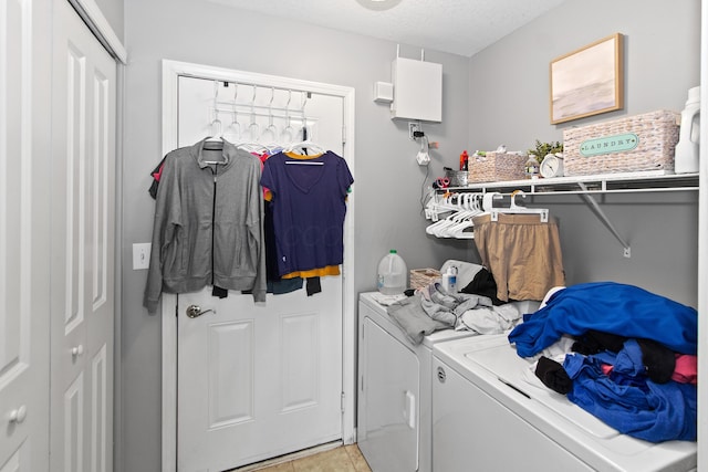 washroom featuring laundry area, a textured ceiling, separate washer and dryer, water heater, and light tile patterned flooring