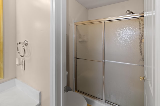 full bath featuring toilet and a stall shower