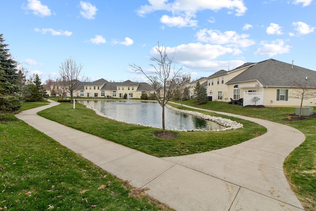 view of property's community with a water view, a yard, and a residential view