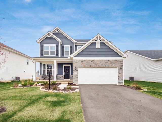 9239 Horseshoe St, Plain City, OH 43064 - craftsman-style home with driveway, a front yard, covered porch, stone siding, and a garage