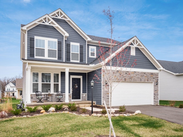 9239 Horseshoe St, Plain City, OH 43064 - craftsman-style house with an attached garage, driveway, covered porch, and stone siding