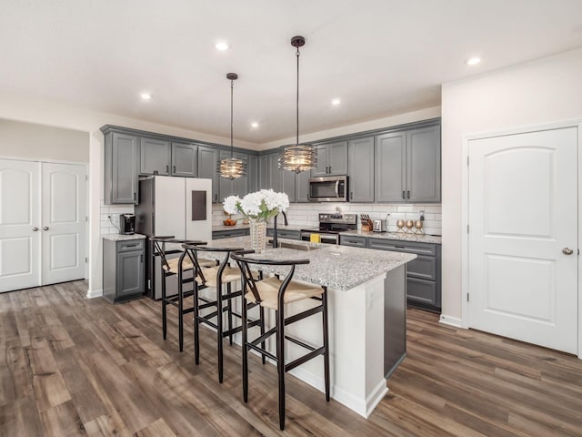 9239 Horseshoe St, Plain City, OH 43064 - kitchen featuring dark wood-style flooring, an island with sink, stainless steel appliances, and gray cabinetry