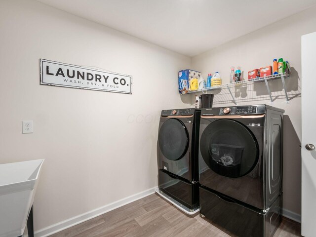 9239 Horseshoe St, Plain City, OH 43064 - washroom with washing machine and clothes dryer, baseboards, wood finished floors, laundry area, and a sink
