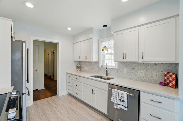 1800 Timberline Dr, Springfield, OH 45504 - kitchen featuring a sink, stainless steel appliances, light wood finished floors, and white cabinetry