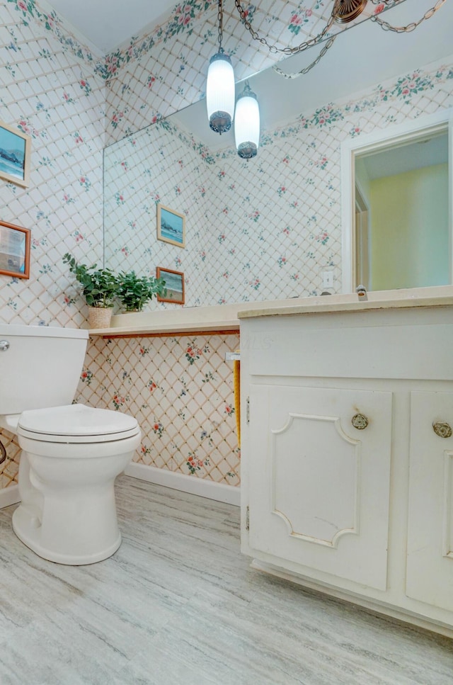 1800 Timberline Dr, Springfield, OH 45504 - bathroom featuring baseboards, toilet, wallpapered walls, and wood finished floors