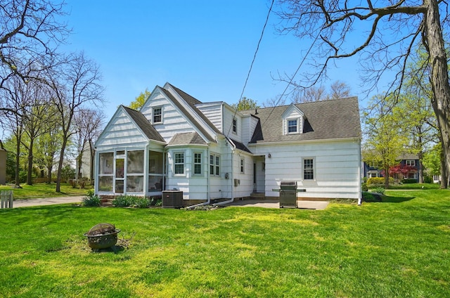 1800 Timberline Dr, Springfield, OH 45504 - back of house with a sunroom, a fire pit, central AC, and a lawn