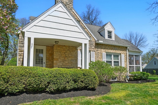1800 Timberline Dr, Springfield, OH 45504 - view of front of house featuring a sunroom, a front lawn, a chimney, and stone siding