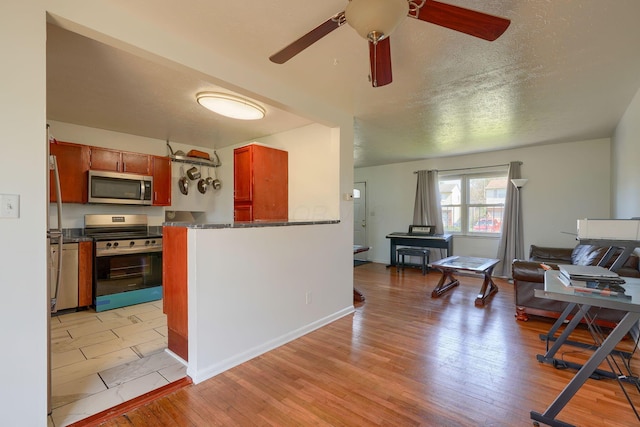 1473 Venice Dr, Columbus, OH 43207 - kitchen with dark countertops, open floor plan, ceiling fan, light wood finished floors, and appliances with stainless steel finishes