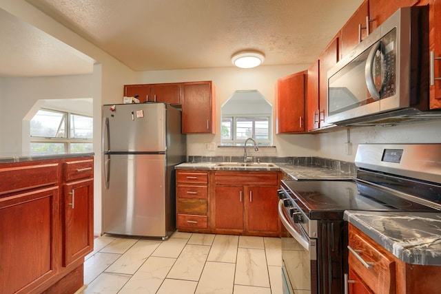 1473 Venice Dr, Columbus, OH 43207 - kitchen featuring a sink, a textured ceiling, marble finish floor, stainless steel counters, and appliances with stainless steel finishes