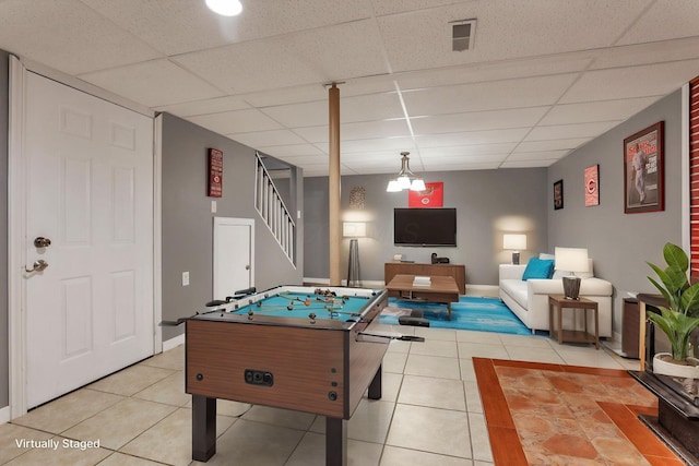 recreation room with light tile patterned floors, a paneled ceiling, and baseboards