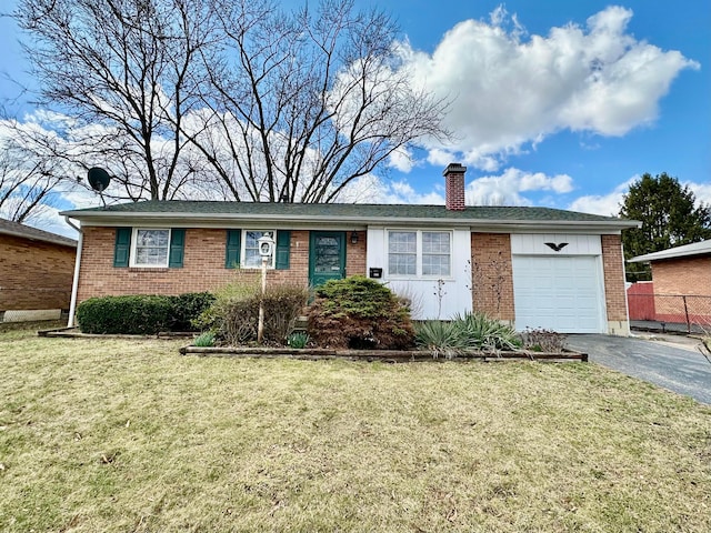 ranch-style house featuring a chimney, a garage, brick siding, a front lawn, and driveway