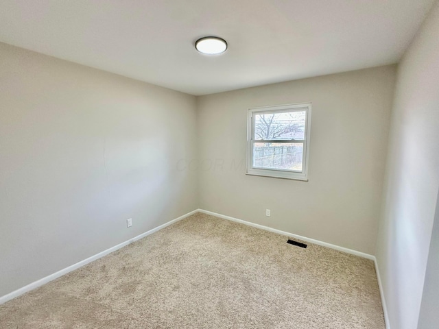 carpeted empty room featuring baseboards
