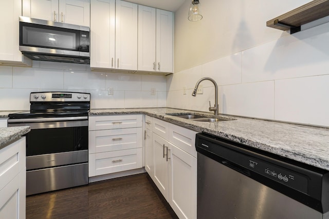 kitchen with white cabinets, a sink, appliances with stainless steel finishes, and tasteful backsplash
