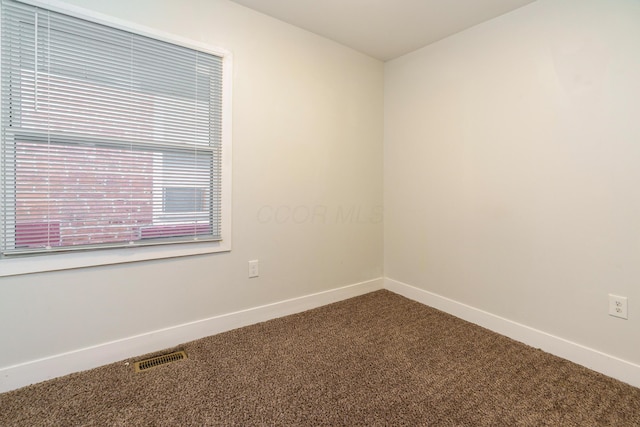 unfurnished room featuring baseboards, carpet flooring, and visible vents